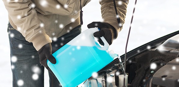 Man-Pouring-Wiper-Fluid-In-Car